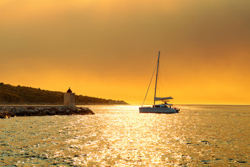 Yacht getting ready to be moored in the harbor of a small town Postira - Croatia, island Brac