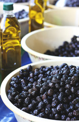 Black olives in bowls and bottles with olive oil at the eastern market