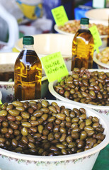 Pickle olives in bowls and bottles with olive oil at the eastern market