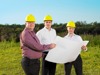 Three surveyors on a field.