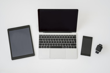 Laptop , tablet , smart phone and smartwatch.on table. Modern digital devices and gadgets.