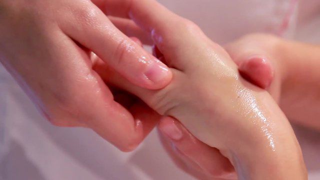 Donna massaggiatrice massaggia una ragazza in relax