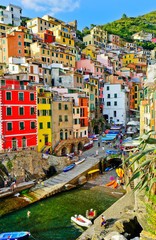 Fototapeta na wymiar View of the colorful houses along the coastline of Cinque Terre area in Riomaggiore, Italy.