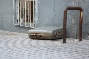 Fototapeta na wymiar A suitcase lying alone on the street