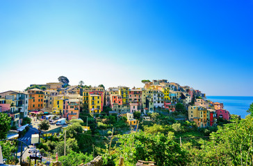 Fototapeta na wymiar View of the colorful houses along the coastline of Cinque Terre area on a sunny day in Corniglia, Italy.