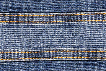 Jeans blue denim strip with brown thread sew pattern.