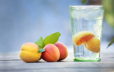 Summer cocktail with pieces of fruit on wooden table