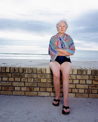 A mature woman sitting by the sea