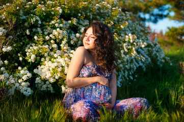 Pregnant caucasian woman takes rest outdoor