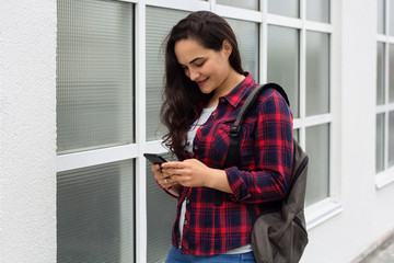 young girl student in a campus uses a mobile phone