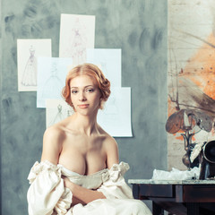 Beautiful woman in vintage dress in clothing design studio