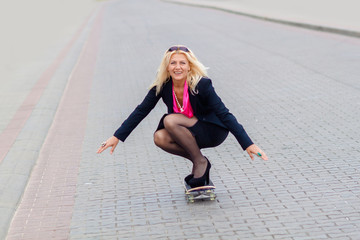 Senior business woman having fun on a skateboard outdoors. The concept of moving forward.