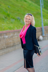 Senior business woman having fun on a skateboard outdoors. The concept of moving forward.
