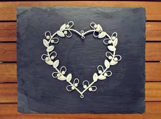 Fototapeta na wymiar white metal heart on a slate background