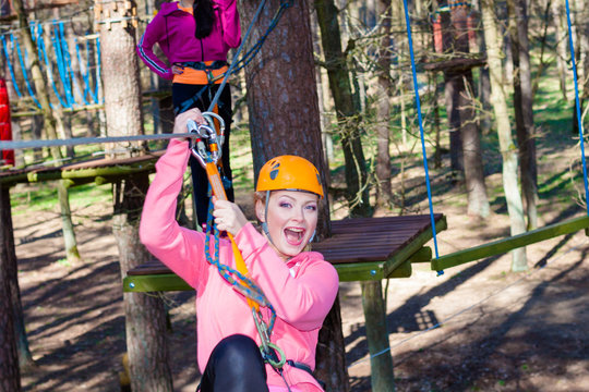 Cheerful attractive girl in a special outfit engaged in rock climbing.