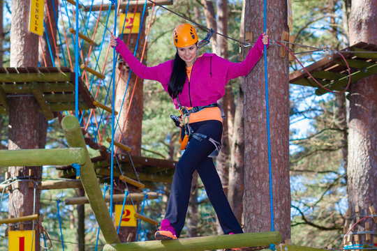 Cheerful attractive girl in a special outfit engaged in rock climbing.