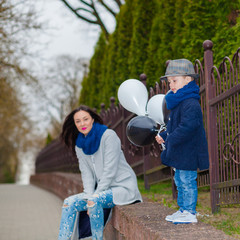 Portrait of fashionable baby boy and his gorgeous mother. little boy hugs his mother emotionally.