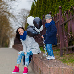 Portrait of fashionable baby boy and his gorgeous mother. little boy hugs his mother emotionally.