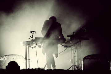 Silhouette of a keyboardist in stage lights