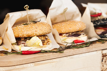 Fresh hamburgers wrapped in paper on a wooden table