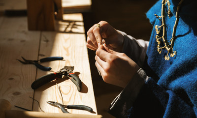 Female craftsman hands working with jewellery, selective focus