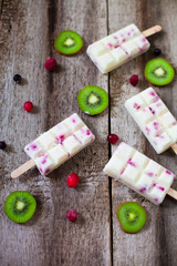 Summer fruits and berry homemade lolly pops ice cream. Group of homemade popsicles on a rustic background