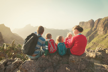 family with three kids hiking in mountains