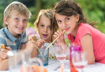 Fototapeta premium Three Children having a snack in the garden