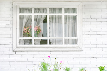 White window with bouquet of flowers, white brick wall