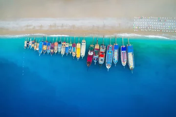 Foto auf Acrylglas Luftaufnahme Strand Luftaufnahme von bunten Booten im Mittelmeer in Ölüdeniz, Türkei. Schöner Sommermeerblick mit Schiffen, klarem azurblauem Wasser und Sandstrand an sonnigen Tagen. Draufsicht auf Yachten von fliegender Drohne