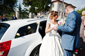 Naklejka premium Fantastic wedding couple getting in the limousine.