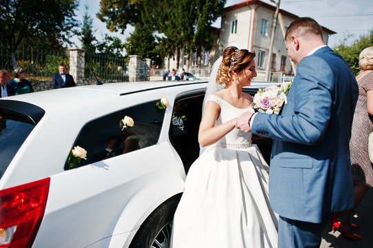 Fantastic wedding couple getting in the limousine.