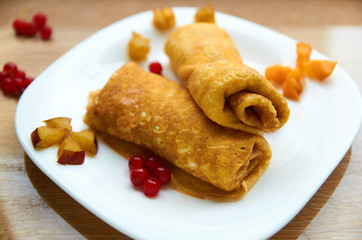 Crepes with  with cheese and fresh berries on white plate. Side view