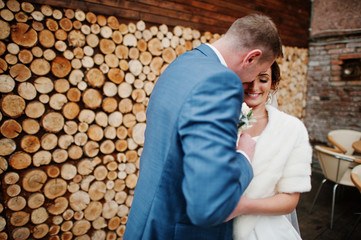 Perfect newly married couple posing on the wooden background.