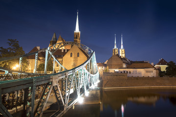 Obraz premium Evening photo of illuminated bridge and St. John the Baptist Cathedral in Wroclaw, Poland