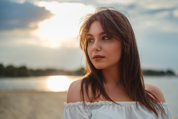 Girl on the beach with sun behind her