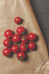 Fresh red cherry vine tomatos on a brown paper background