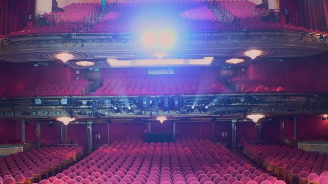 Camera movement from stage to stalls and amphitheaters with counter lights