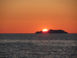 Beautiful sea sunset with island silhouette panorama . View of Gorgona island from Livorno city . Tuscany, Italy