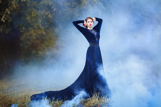 A Slender Girl In A Long Dress In A Blue Fog.