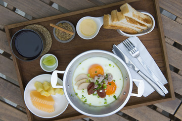 Fototapeta na wymiar Indo China Vietnamese Pan fried eggs with bread, milk, fruits as breakfast set. 