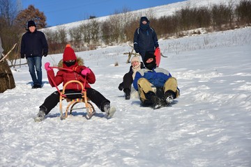 Happy Family sledding in winter on the snow