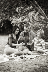 Cheerful family sitting on the grass during un picnic in a park