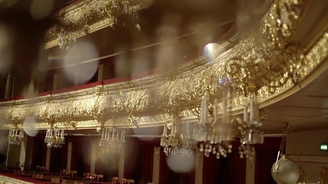 Interior of the old castle or theatre. Beautiful gallant large chandeliers with light candles and dark side background in the theatre.