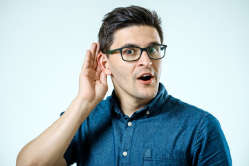 Head shot of man trying listen gossip or news. Isolated on grey background