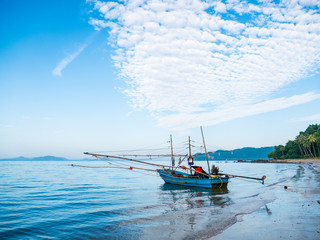 Fototapeta premium Alone fishing boat with net wooden arms moored in the sea
