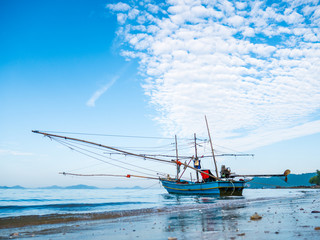Fototapeta premium Alone fishing boat with net wooden arms moored in the sea