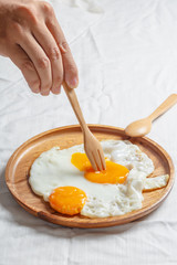 Fried egg with wood fork
