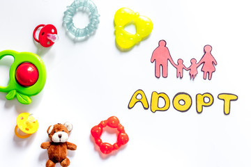 Adopt word, paper silhouette of family and toys on white background top view copyspace