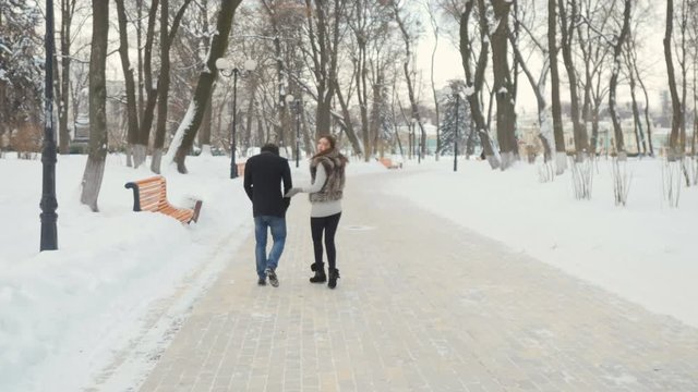 Handsome people walk in the winter park